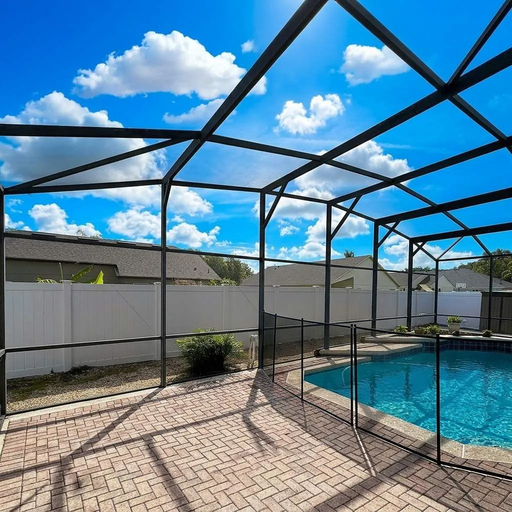 Inside a pool enclosure, gable frame over the pool and paver deck